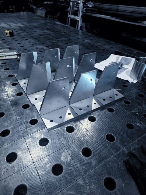 Rows of gusset plates standing on base plates on the fixture table