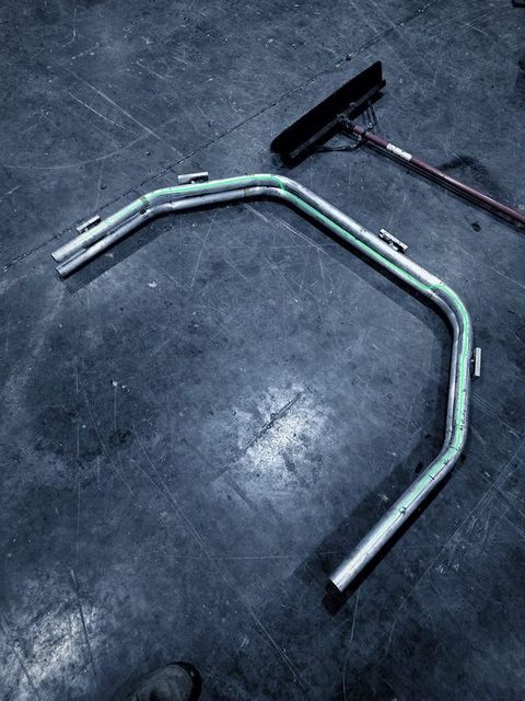 A bent tube arch lying on the shop floor