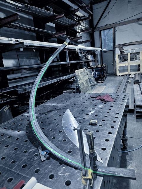 A long bar rolled to a curve on the fixture table