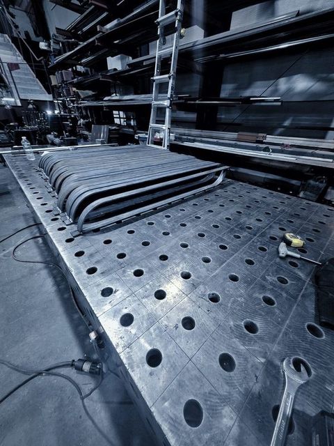 Bent flat bar frames stacked flat on the fixture table