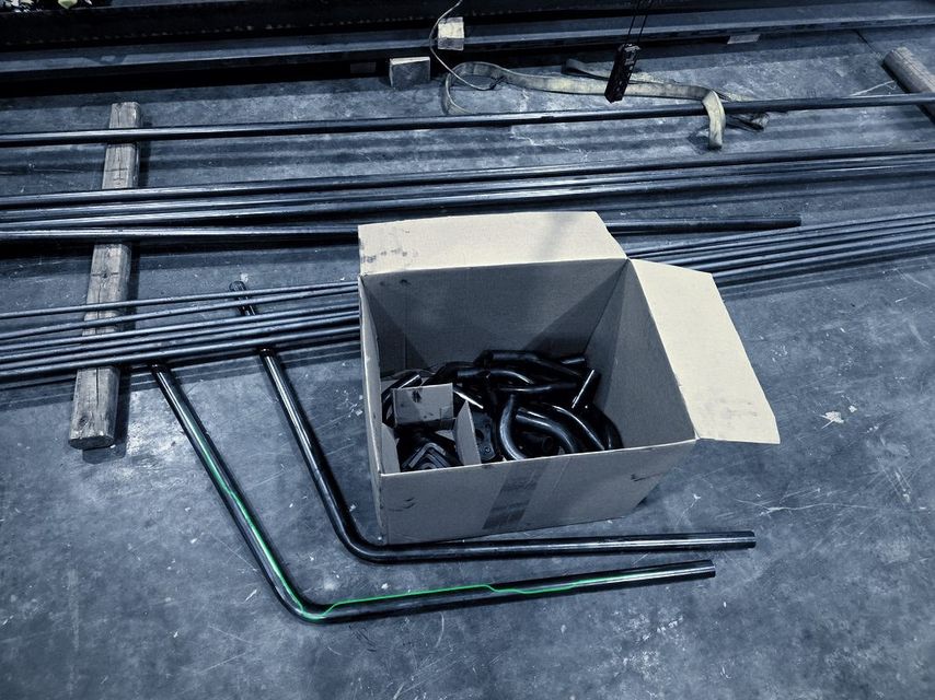 An open carton of bent tube parts on the shop floor