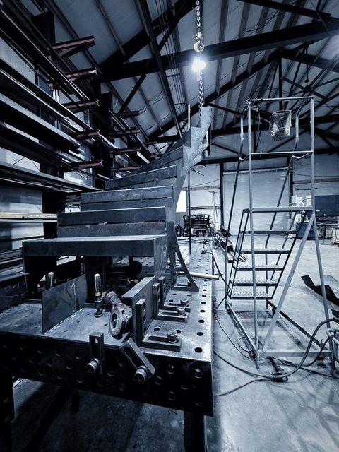 Stair treads stacked up on the fixture table beside a rolling ladder