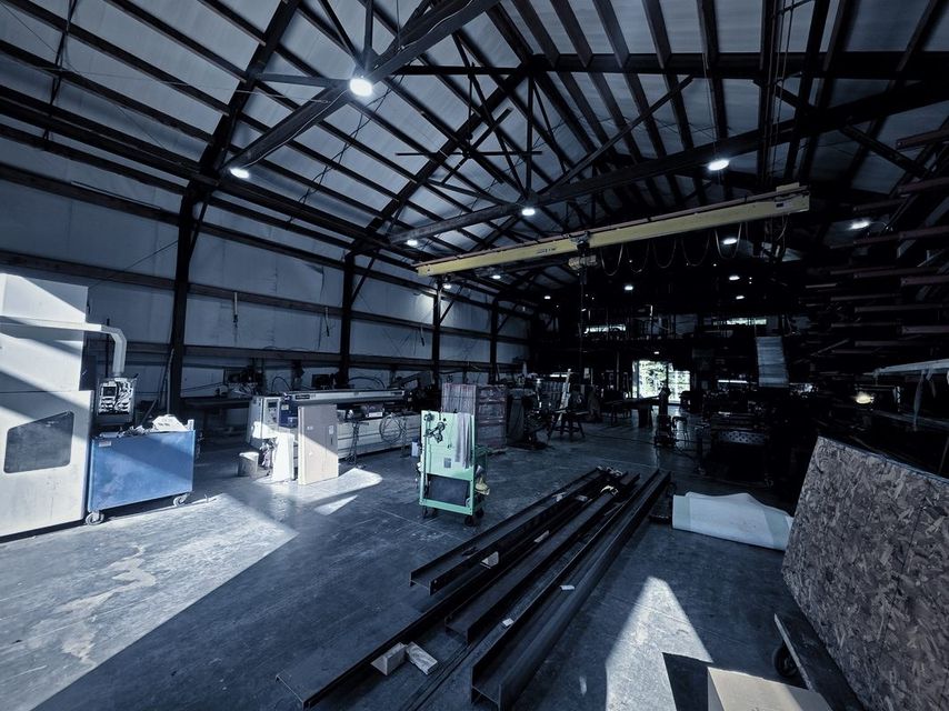 A wide view of the shop with steel channel laid out on the floor under the bridge crane
